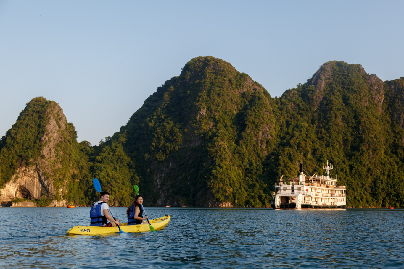 Families with teenagers enjoying an outdoor adventure while kayaking in Ha Long Bay.