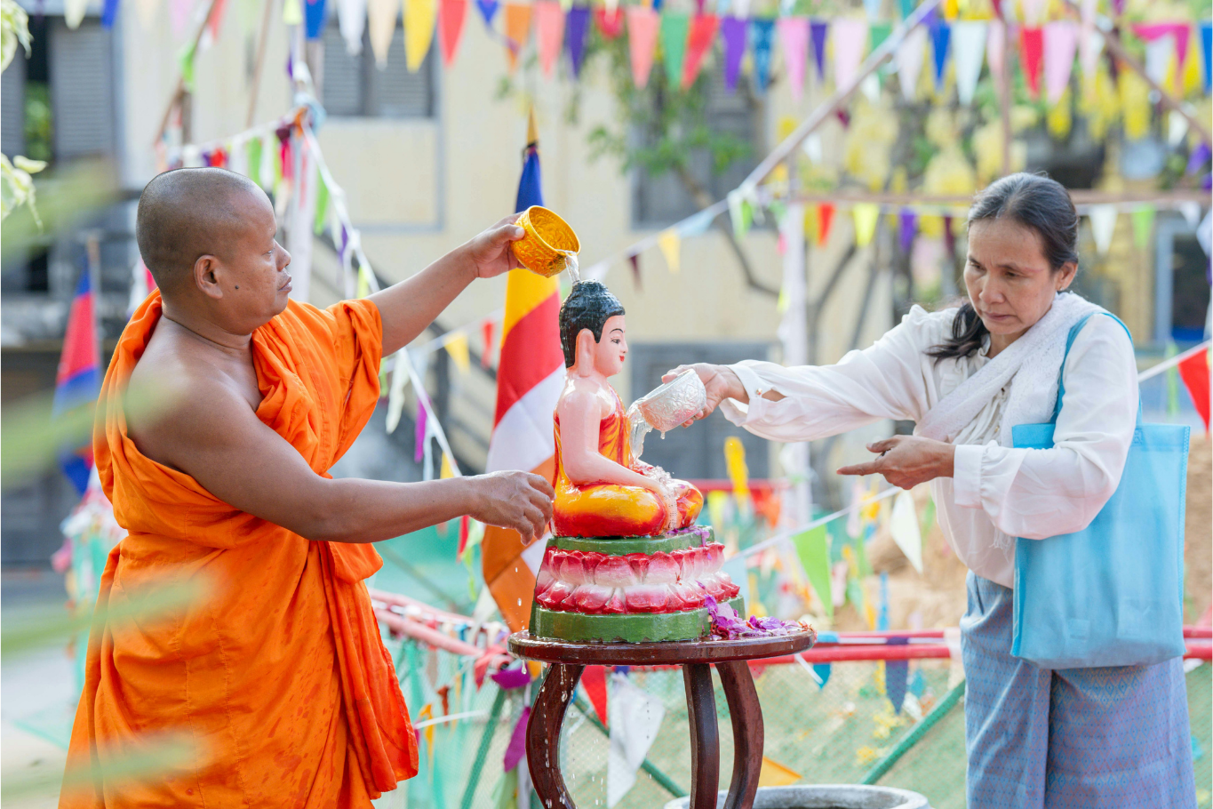 People pouring scented water over Buddha statues as part of the Choul Chnam Thmey celebrations.