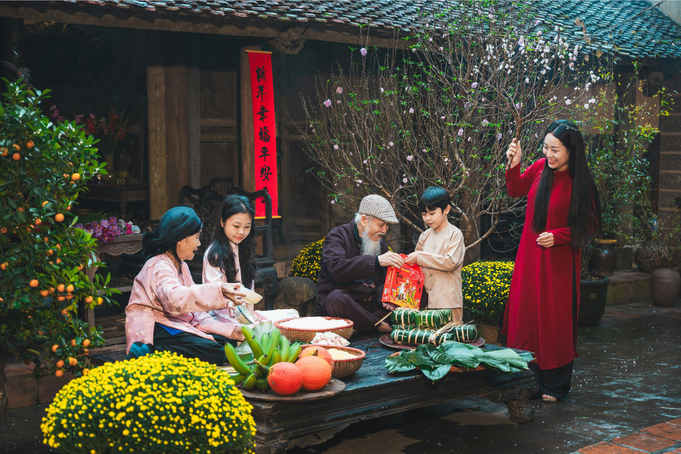 A Vietnamese family gathering outdoors to wrap bánh chưng and bánh tét for Tet