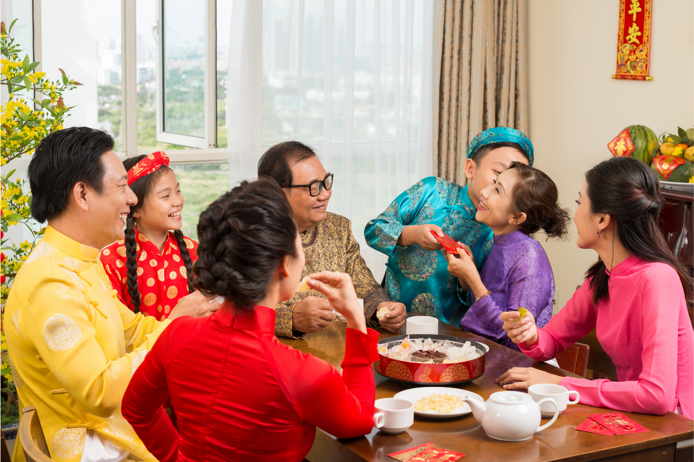 A Vietnamese family enjoying traditional holiday treats together during Tet, one of the most cherished Southeast Asian festivals.