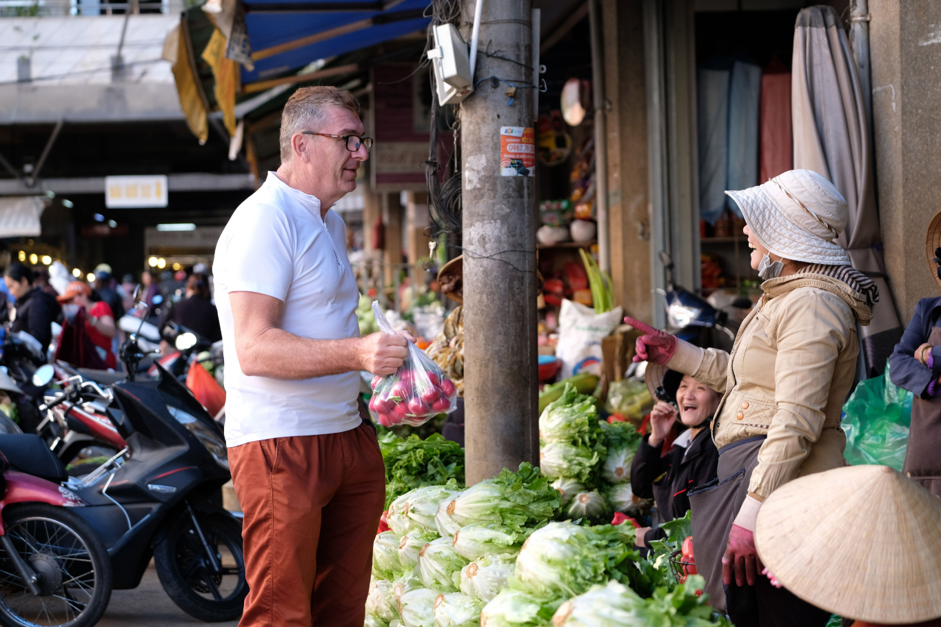 Traveler interact with a local vendor at a Vietnamese market