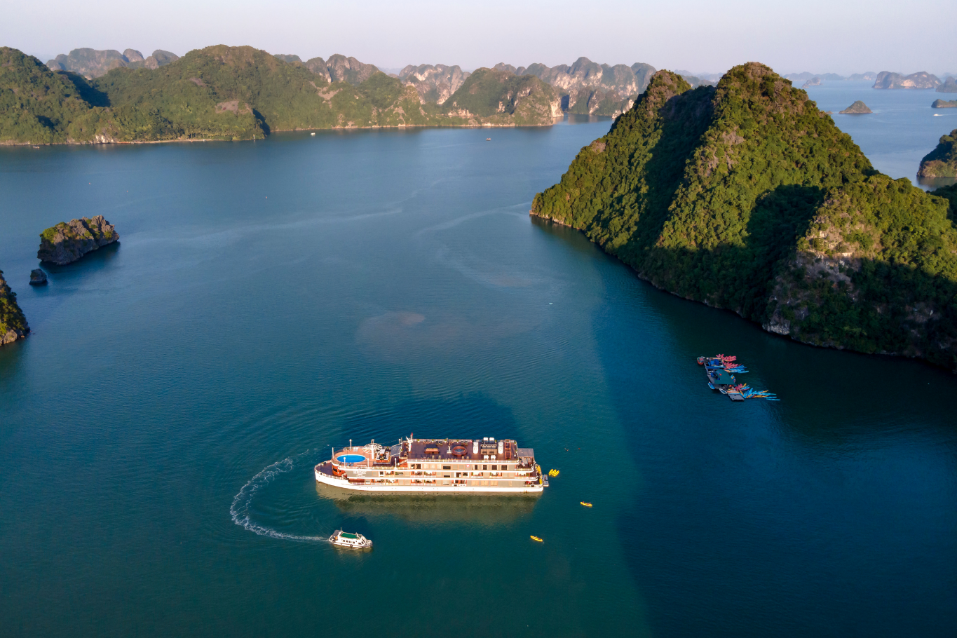 Cruise ship sailing through the tranquil waters and towering limestone islets of Ha Long Bay