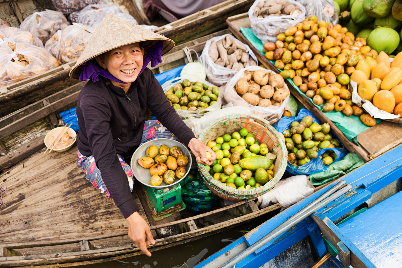Vendor selling tropical fruits on a boat at Mekong Delta