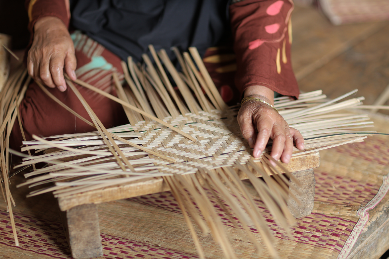 Weaving bamboo strips on a wooden loom in Vietnam