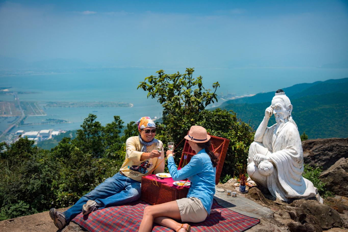 A private luxury picnic and wine toast on a scenic mountain summit overlooking the ocean in Vietnam