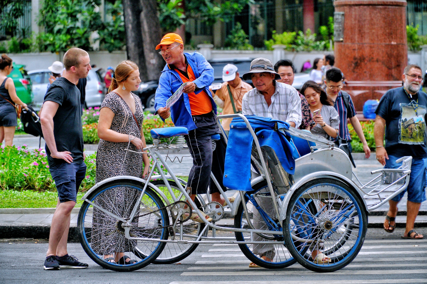 Family interacting with a friendly cyclo driver on a bustling Vietnamese street