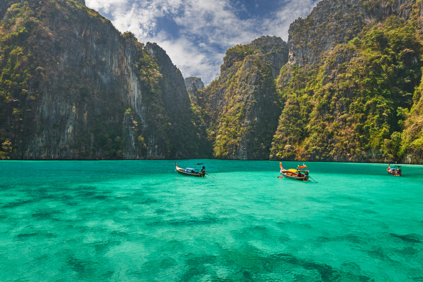Longtail boat navigating crystal clear waters during Thailand beach escapes.