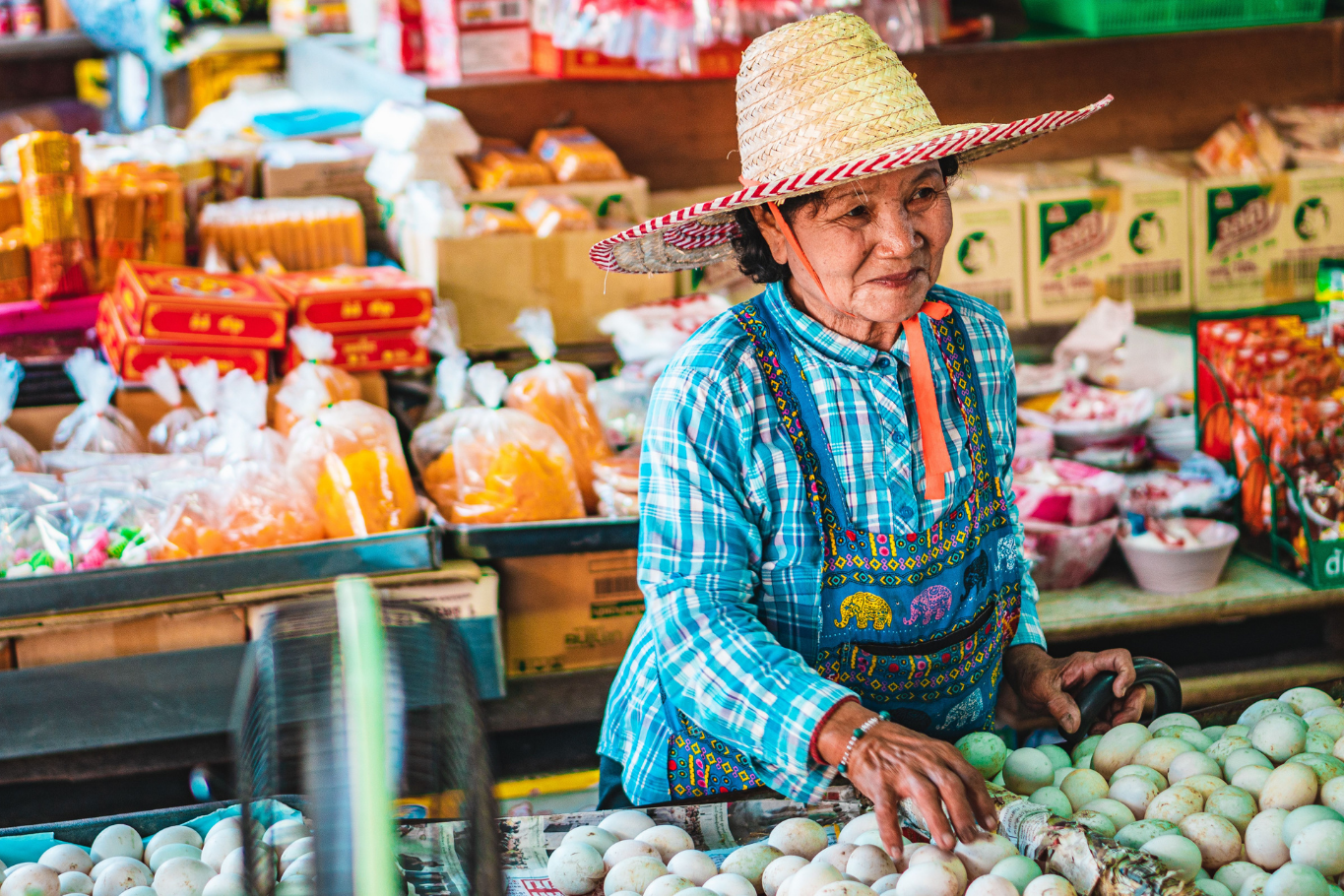 Local Thai woman selling fresh produce at a vibrant market.