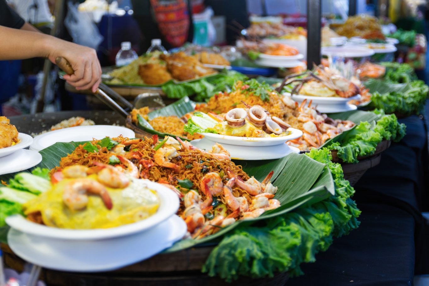 Colorful Thai street food dishes and seafood served on banana leaves.