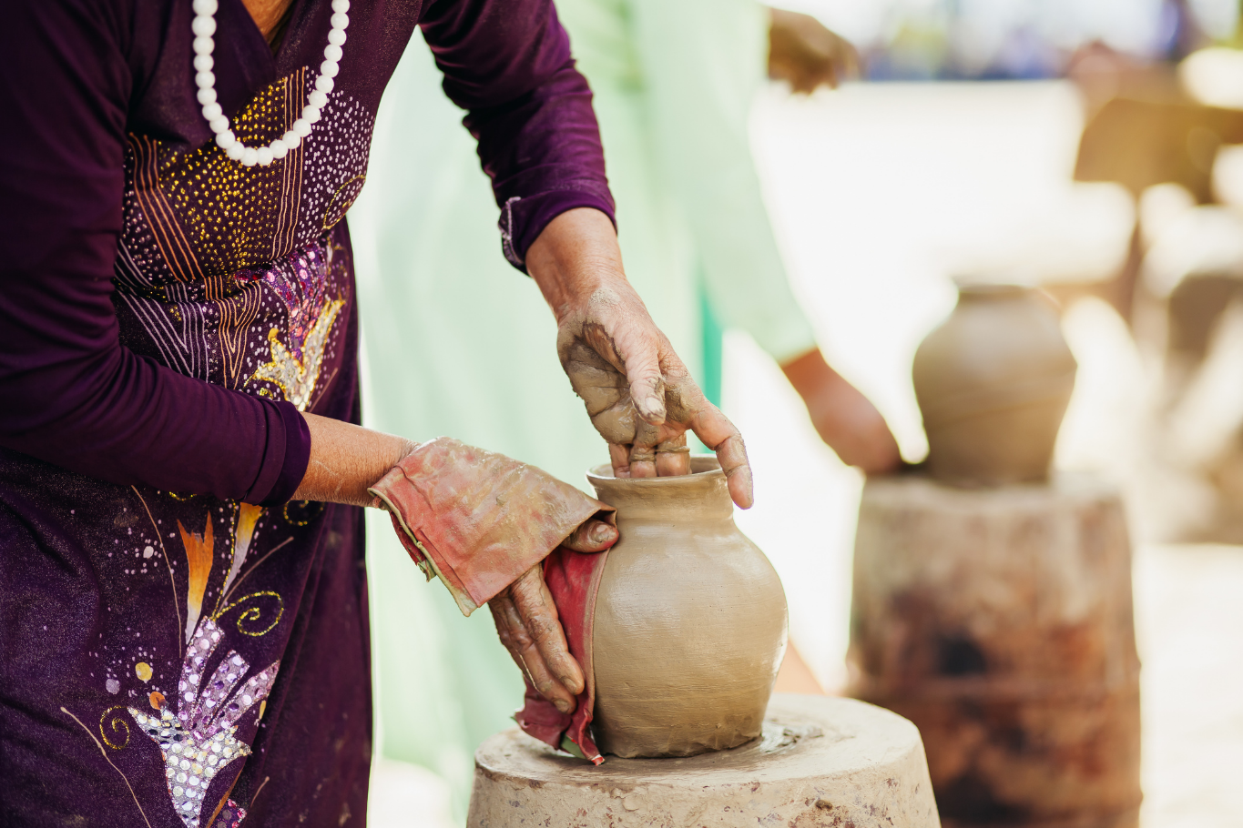 Craftsperson molding ceramic pottery by hand