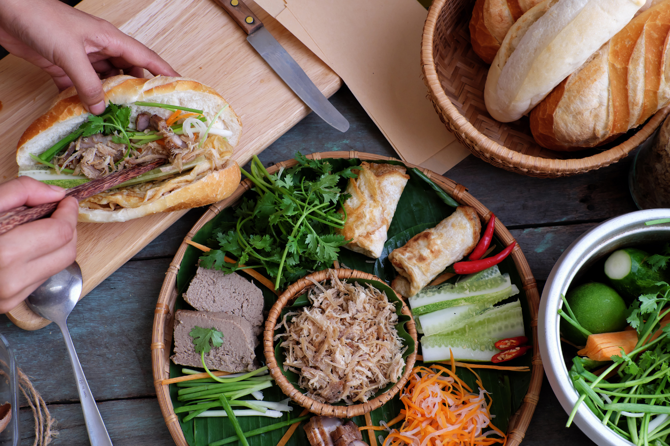 A top-down view of hands preparing a Vietnamese Banh Mi
