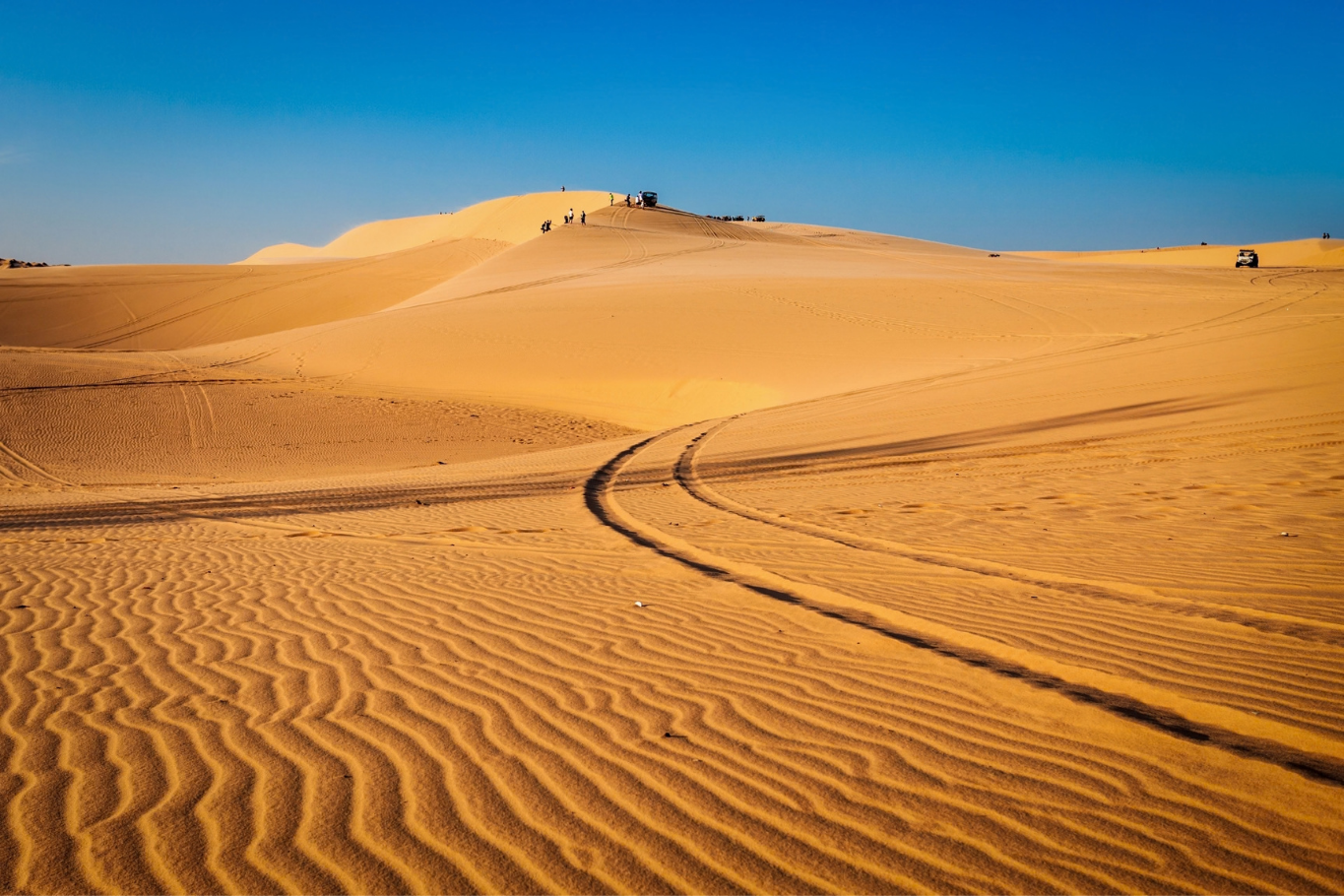 Vast sand dunes under a clear blue sky in Mui Ne